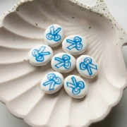 Perle ovale 19x16 mm en céramique - motif noeud - Blanc - Bleu x1