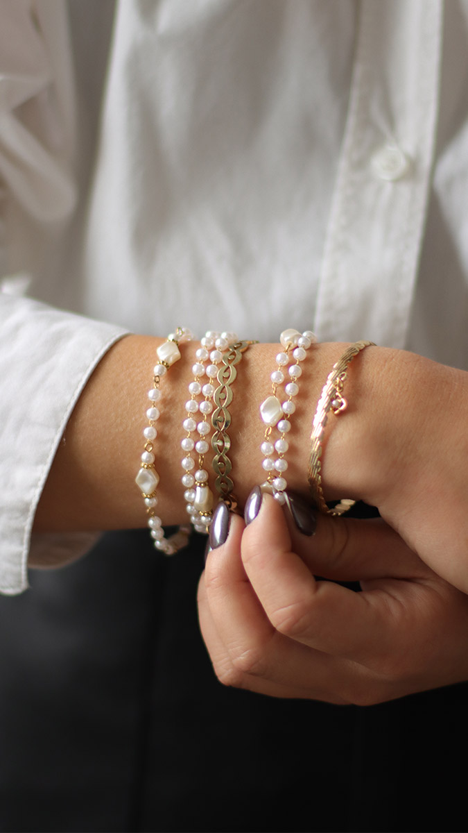 Stacking de bracelets dorés et perles imitation nacre
